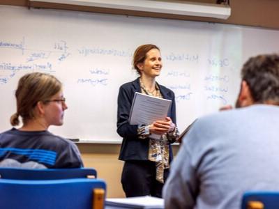 Professor Laura Eidt in front of whiteboard with German sentence diagrams